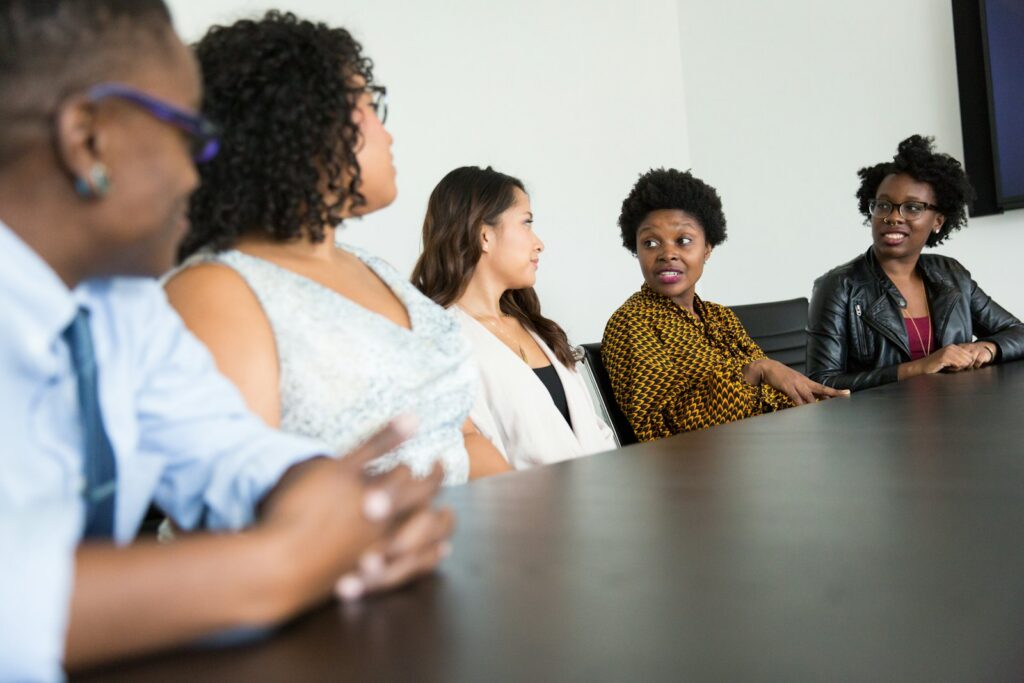 Community members of different backgrounds talk around a table