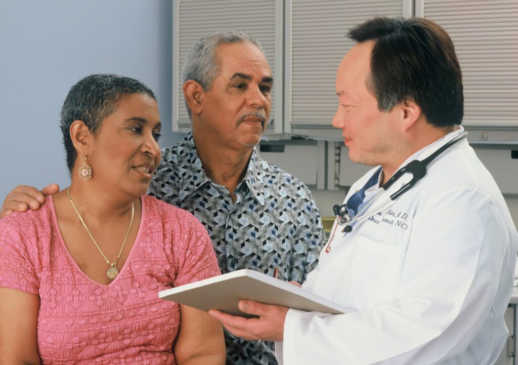 A doctor speaks with an older couple
