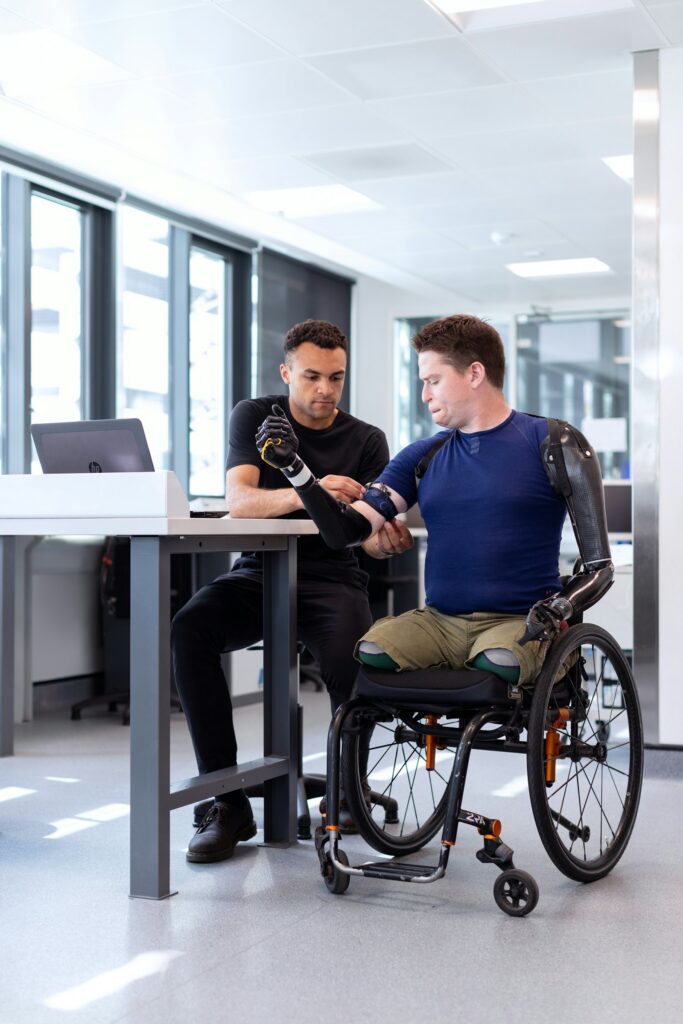 Two colleagues work together, one using a wheelchair