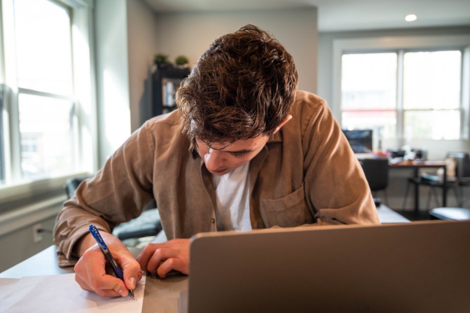 Man filling out an application form at his desk